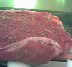 a close-up of said piece of meat; see the seasonings on the skin