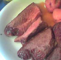 sliced roast and small red potatoes on a plate
