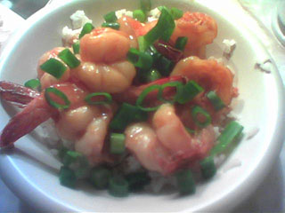 a bowl of red-orange shrimp over rice
