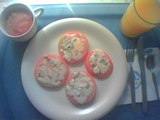 a plate of tomatoes with melted cheese on them